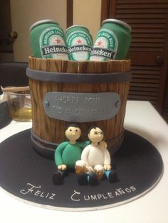 a cake made to look like two people sitting in front of a barrel filled with beer