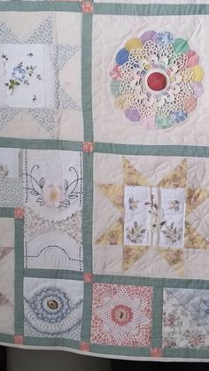 a quilted wall hanging with many different designs on it