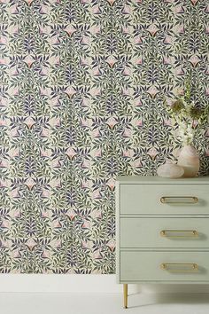 an ornate wallpaper design with pink, blue and green flowers on the sideboard