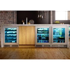 two refrigerators sitting next to each other on a wooden floor