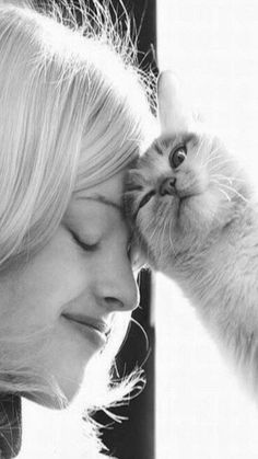 black and white photograph of a woman kissing a cat