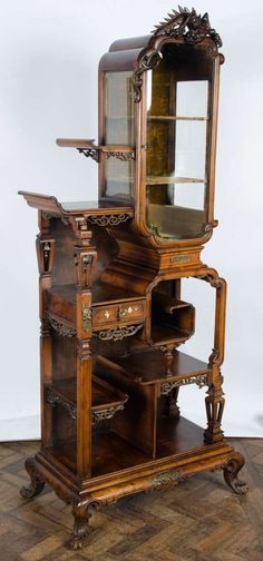 an antique wooden dresser with glass doors and drawers