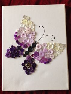 a butterfly made out of buttons sitting on top of a piece of paper