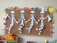 a bulletin board with paper skeletons and birds on it