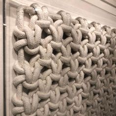 a close up of a knitted curtain hanging on a wall