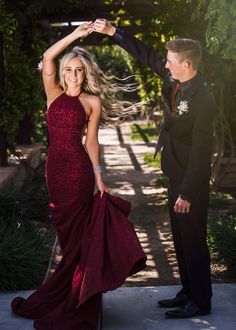 a woman in a red dress standing next to a man