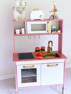 a pink and white play kitchen with sink