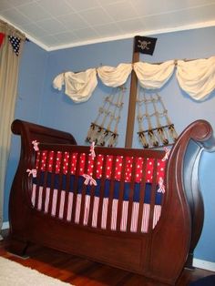 a baby crib is decorated with red, white and blue fabric on the bed