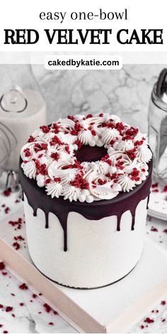 a red velvet cake with white frosting and sprinkles on top is shown