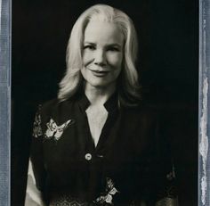 an old black and white photo of a woman with long blonde hair wearing a blouse