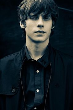 a young man in a black shirt and tie