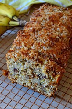 a loaf of banana bread sitting on top of a cooling rack next to two bananas