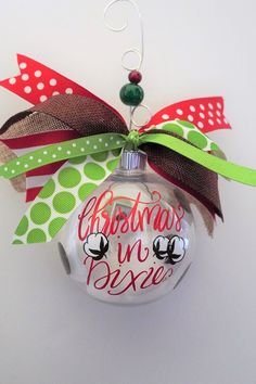 a christmas ornament hanging from the side of a wall with ribbon on it