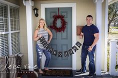 a man and woman standing in front of a door holding signs that say happy holidays