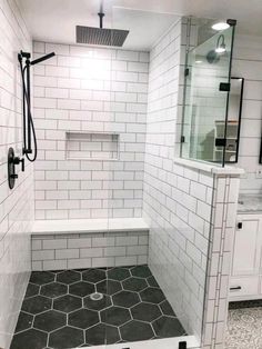 a white tiled bathroom with black and white tile