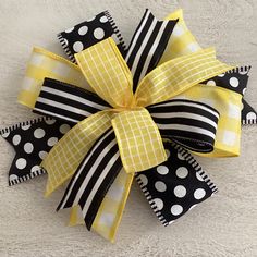 a black and white polka dot bow with yellow ribbon