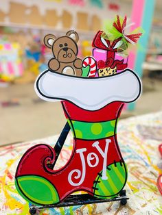 an ornament with a teddy bear in a christmas stocking on top of it