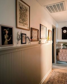 there are pictures on the wall above the dresser in this hallway, along with other art and decor