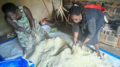 two women are making something out of sand