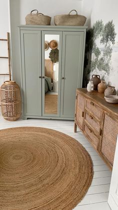 a room that has some baskets on top of the cupboards and a rug in front of it