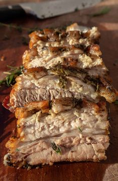 sliced meat sitting on top of a wooden cutting board