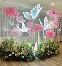 some pink flowers and grass on a wooden floor