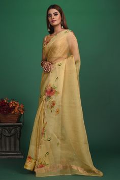 A very unique saree with Handloom Cotton Silk fabric till the pleats and Chanderi fabric with Bronze motifs which is translucent in the front. It also has a Pallu with bronze weave and fringes which makes the whole saree really exquisite. The entire saree has a Golden border. Enhance with a beautiful floral pattern, the vintage design enhances the royal look of the saree. Made with an intricate technique, this is a heritage of its own kind. With a rich border enveloping the saree, it is a stella Transitional Yellow Tissue Silk Pre-draped Saree, Transitional Tussar Silk Saree With Sheer Dupatta, Cotton Silk Saree With Resham Embroidery For Celebration, Transitional Celebration Chanderi Pre-draped Saree, Designer Organza Blouse Piece With Zari Weaving, Organza Blouse Piece With Zari Weaving, Pre-draped Organza Saree With Zari Weaving, Organza Pre-draped Saree With Zari Weaving, Gold Organza Saree With Zari Weaving