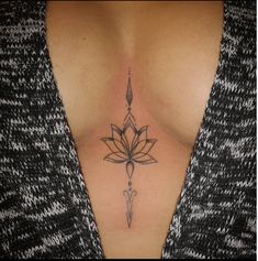 a woman's chest with a lotus tattoo on the top and bottom part of her stomach