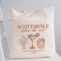 a tote bag sitting on top of a white chair next to a cactus plant