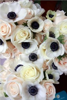 a bouquet of white and pink flowers sitting on top of a table