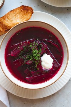 a bowl of soup with sour cream and garnish