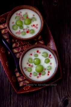 two bowls of yogurt with grapes on top