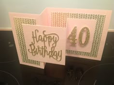 two birthday cards with the number forty on them, one is gold and the other is pink