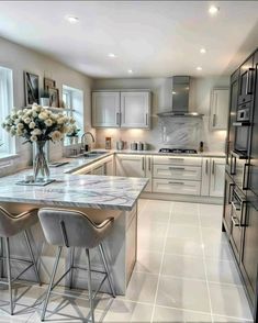 a kitchen with marble counter tops and stools in front of the stove top oven