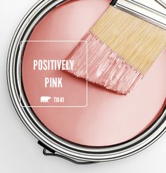 a pink paint can with a brush in it and the words positively pink