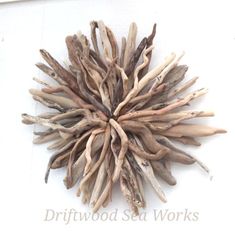 driftwood sea works is displayed on the white wall in front of it's frame