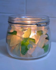 a jar filled with sea glass sitting on top of a counter