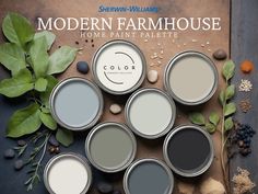 some paint cans are sitting on a table next to plants and rocks with the words modern farmhousee home paint palette