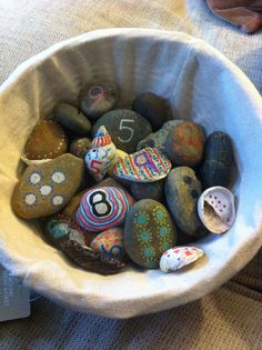 a bowl full of rocks with numbers painted on them