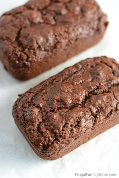 two chocolate brownies sitting next to each other on top of a white paper towel