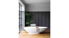 a white bath tub sitting on top of a wooden floor