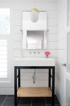 a white sink sitting under a mirror in a bathroom