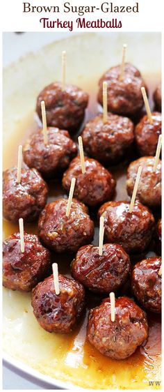 some meatballs are on skewers with sauce and toothpicks in them