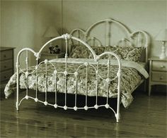 an old fashioned white iron bed in a bedroom