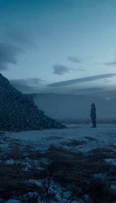 two people standing on top of a pile of rocks