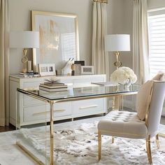 a white and gold desk in a living room with two lamps on either side of it