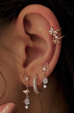 a close up of a person's ear with three different types of earrings on it