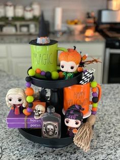 a halloween themed cupcake stand on top of a kitchen counter with candles and decorations