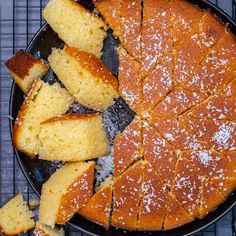 a pan filled with sliced up cake on top of a cooling rack next to bread slices