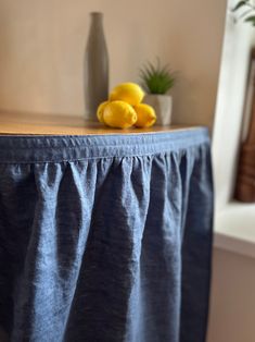 two lemons are sitting on top of a table with a blue cloth draped over it